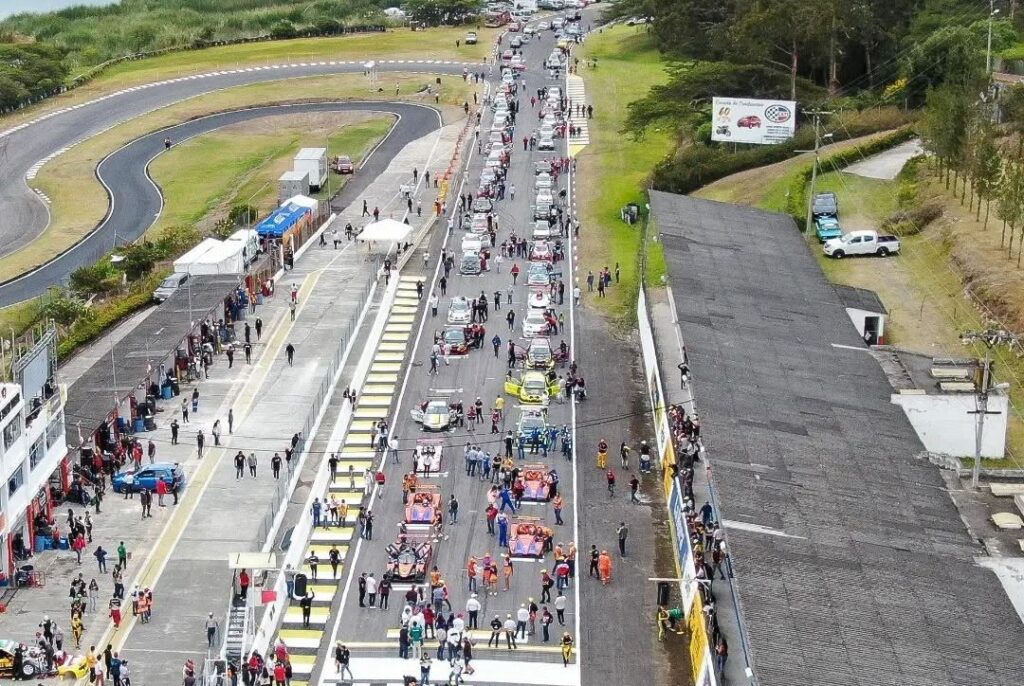 Vehículos de competencia y equipos técnicos se concentran en la zona de pits y la recta principal del Autódromo Internacional de Yahuarcocha, durante una jornada automovilística desarrollada en Ibarra.
