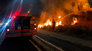 Bombero combate un incendio de vegetación durante una emergencia nocturna en Ibarra