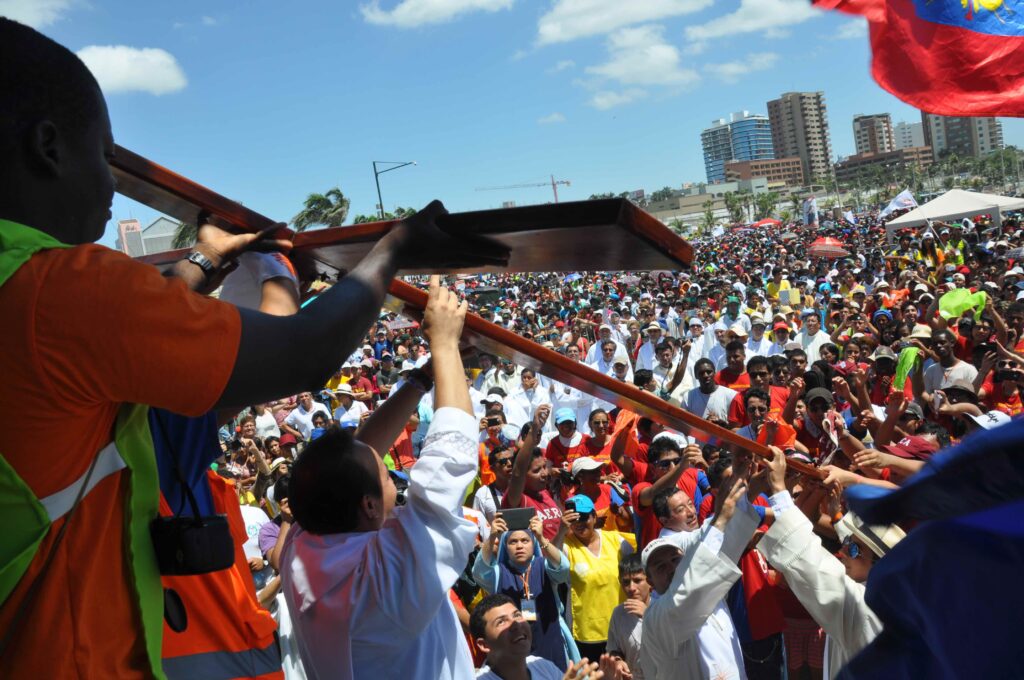 Jóvenes católicos levantan una gran cruz durante una jornada multitudinaria en Ecuador