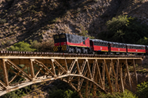 Tren de la ruta ferroviaria Ibarra-Salinas cruza el puente metálico sobre el río Ambi entre las montañas de Imbabura.