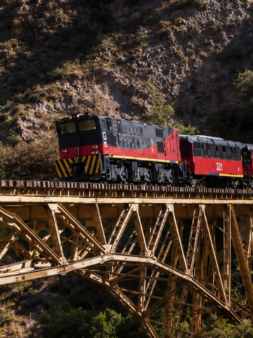 Tren de la ruta ferroviaria Ibarra-Salinas cruza el puente metálico sobre el río Ambi entre las montañas de Imbabura.