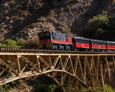 Tren de la ruta ferroviaria Ibarra-Salinas cruza el puente metálico sobre el río Ambi entre las montañas de Imbabura.