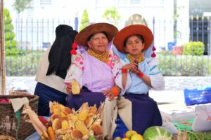 Mujer y niña exhiben maíz y semillas nativas durante el Muyu Raymi en Cotacachi.