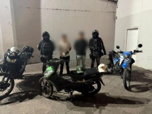 Dos ciudadanos aprehendidos por presunto robo de motocicleta en Ibarra junto a agentes de la Policía Nacional y el vehículo recuperado.