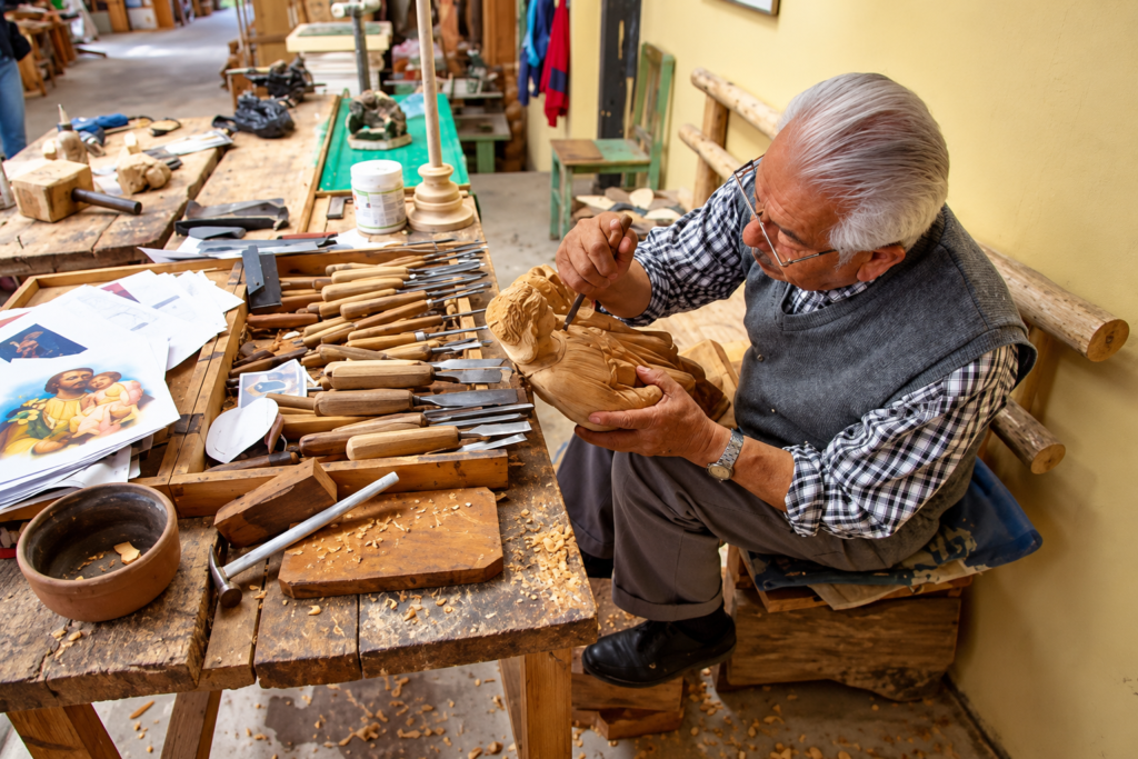 Artesano de San Antonio de Ibarra talla una escultura en madera dentro de su taller.