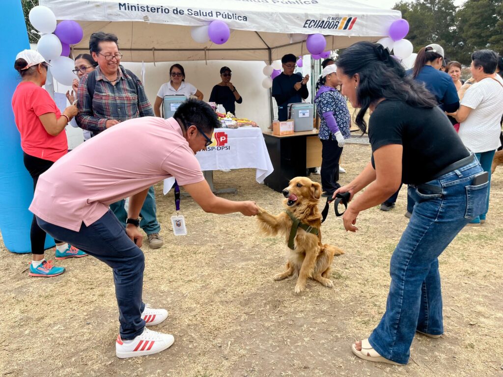 Un perro junto a sus cuidadores y personal de salud durante el lanzamiento de la campaña de vacunación antirrábica en Imbabura.