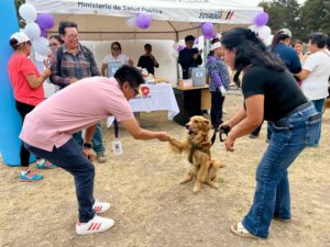 Un perro junto a sus cuidadores y personal de salud durante el lanzamiento de la campaña de vacunación antirrábica en Imbabura.