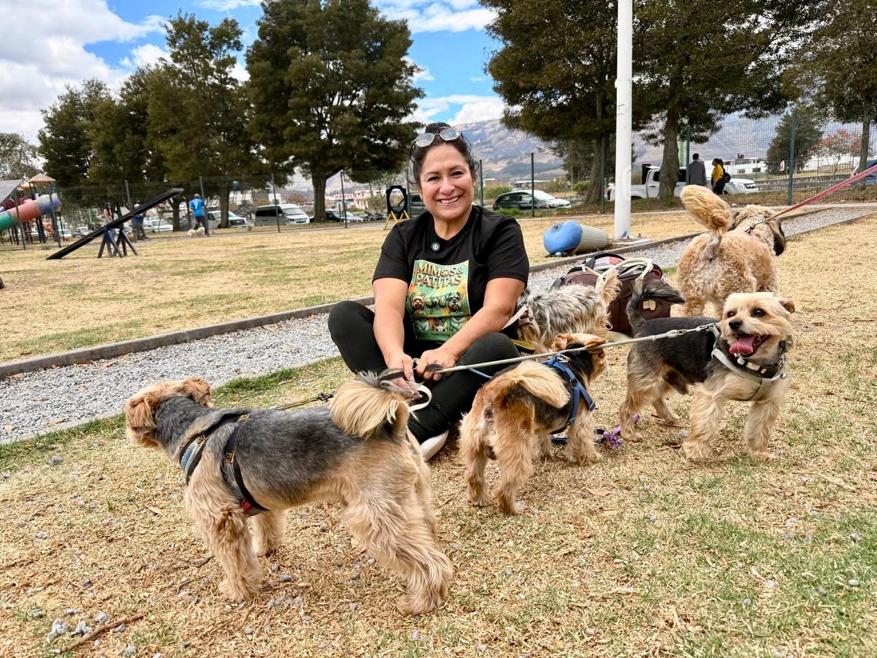Una mujer sostiene las correas de varios perros durante el lanzamiento de la campaña antirrábica en Imbabura.