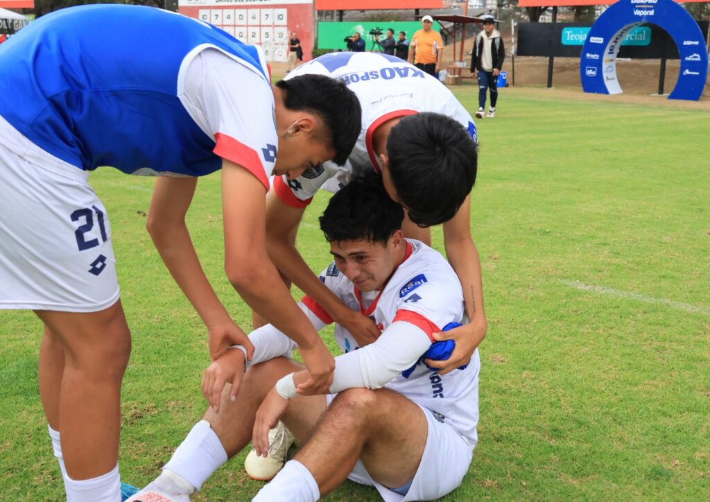Jugadores de la UTN se reúnen en el campo durante un partido de LigaPro Universitaria.