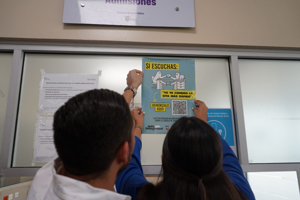 Colocación de un afiche con código QR para denunciar posibles irregularidades en el área de Admisiones del Hospital General Monte Sinaí.
