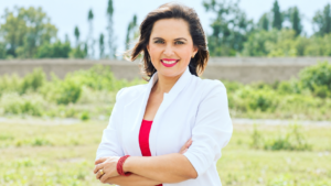 Andrea Cazar Villacís, aspirante imbabureña al cargo de Fiscal General del Estado, posa frente a un paisaje verde.