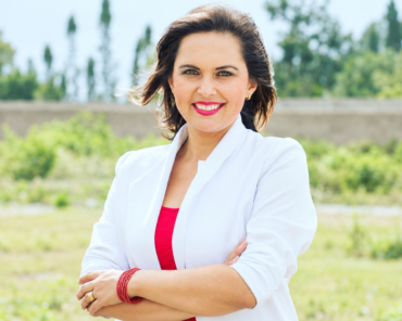 Andrea Cazar Villacís, aspirante imbabureña al cargo de Fiscal General del Estado, posa frente a un paisaje verde.