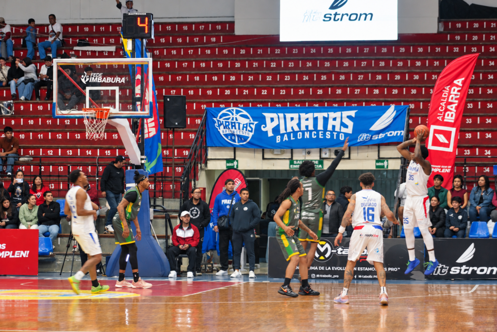 Jugador de Piratas de los Lagos lanza al aro ante la defensa de Zamora Raptors en el coliseo Luis Leoro Franco de Ibarra.