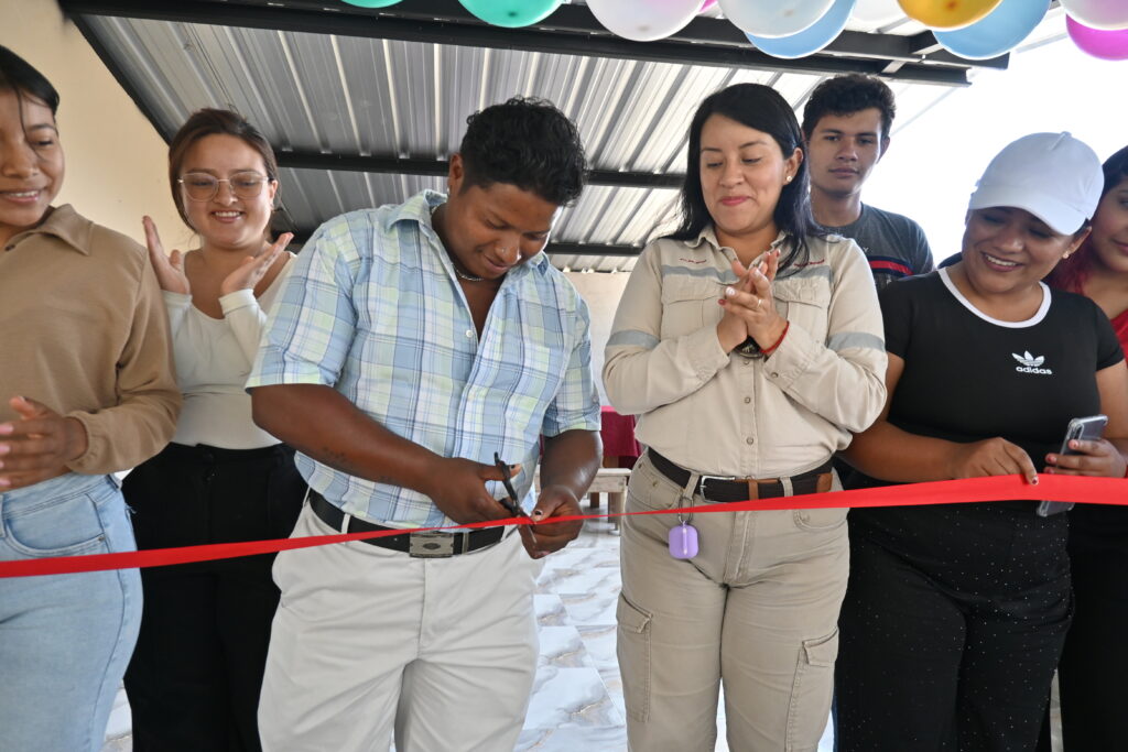 Un hombre corta una cinta roja durante la inauguración de obras en Getzemaní, acompañado por asistentes que aplauden.