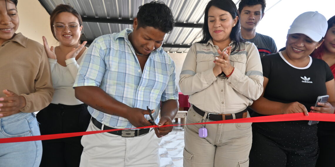 Un hombre corta una cinta roja durante la inauguración de obras en Getzemaní, acompañado por asistentes que aplauden.