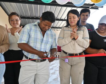 Un hombre corta una cinta roja durante la inauguración de obras en Getzemaní, acompañado por asistentes que aplauden.