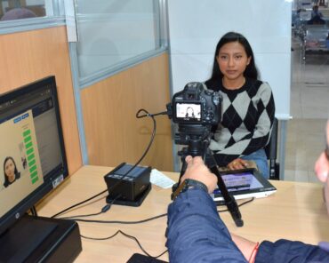Una usuaria posa para la fotografía de su cédula en una oficina del Registro Civil.