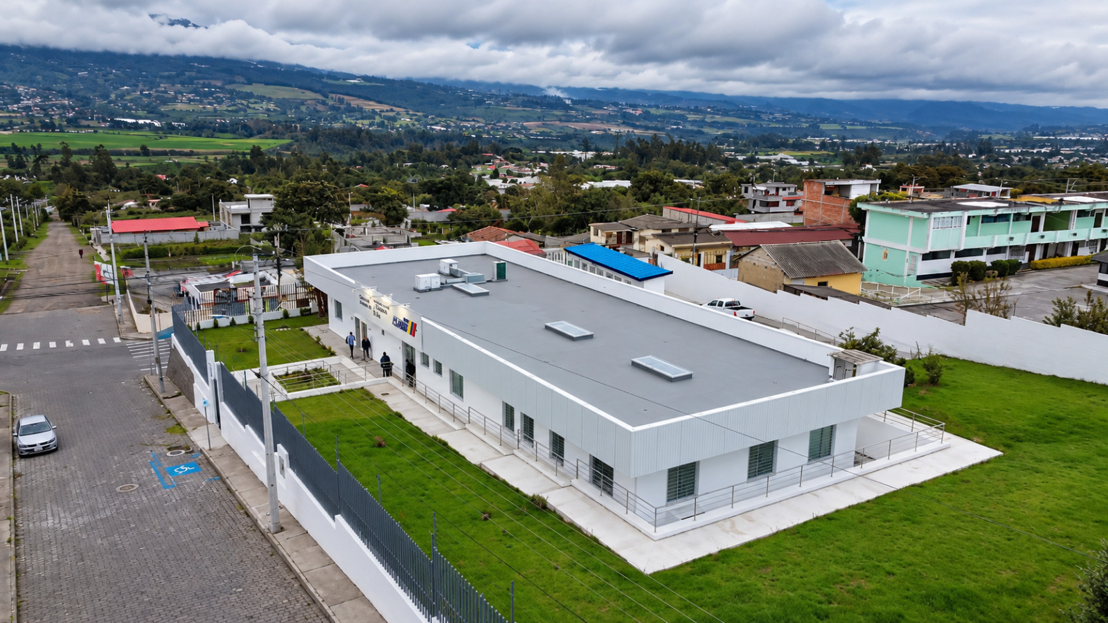 Vista aérea del centro de salud San Roque renovado, con su edificio, rampas de acceso y áreas verdes en Antonio Ante.