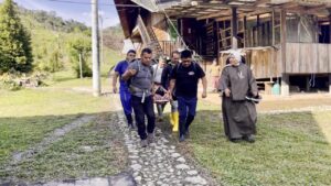 Integrantes de una brigada trasladan a un paciente en camilla junto a una religiosa en San Francisco de Palmira, sector de Lita.