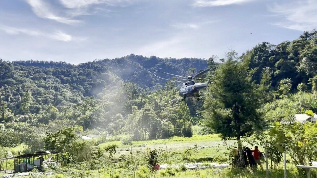 Helicóptero sobre una zona rodeada de montañas y vegetación en San Francisco de Palmira, parroquia de Lita.