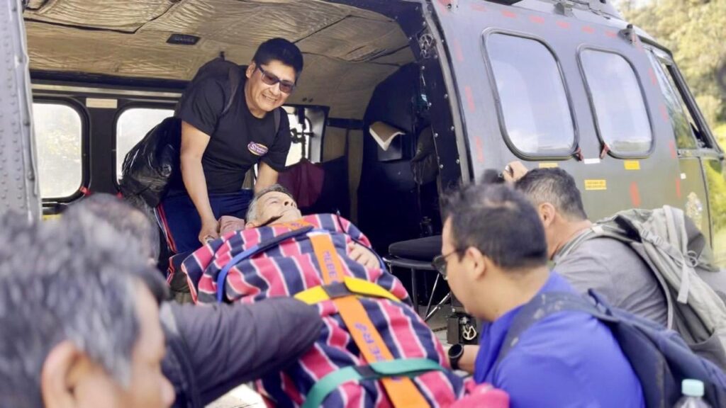 Integrantes de la brigada suben a un adulto mayor en camilla a un helicóptero en San Francisco de Palmira.